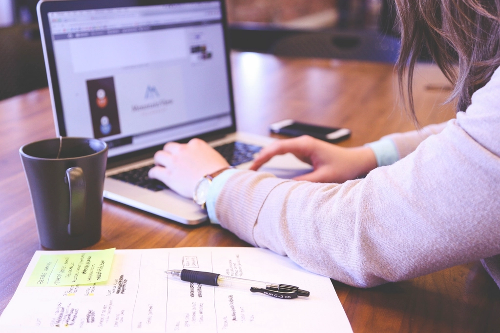 Persona creando su currículum con ayuda de inteligencia artificial en laptop